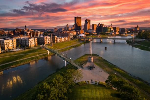 Colorful Cityscape Sunset An aerial drone view over a park looking towards downtown Dayton, Ohio at sunset at the confluence of the Great Miami and Mad Rivers with brightly colored clouds in the sky. dayton ohio skyline stock pictures, royalty-free photos & images