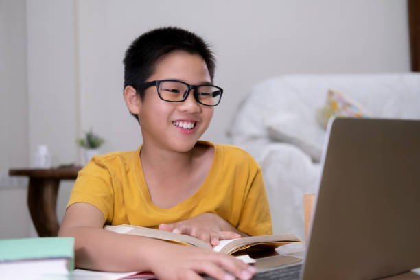 asian boy enjoy self study with e-learning at home. - schoolboy relaxation happiness confidence imagens e fotografias de stock