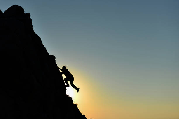 istock rock climbing striker and climber climbing without equipment 1216248736