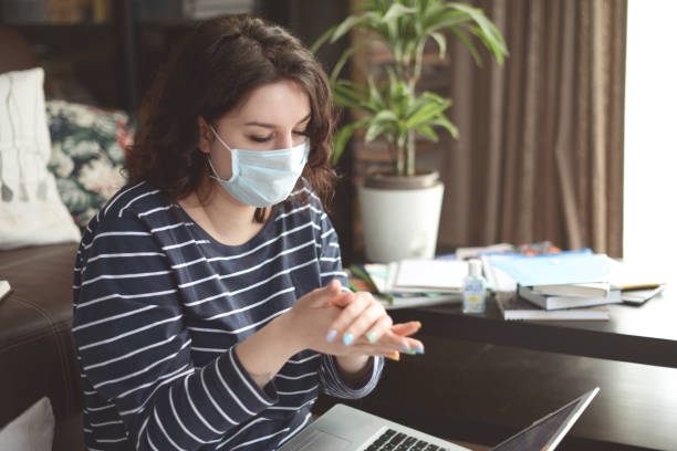 istock Beautiful young woman working at home ( in the mask) 1216249728