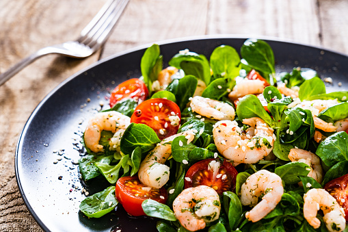 Prawns with vegetables on wooden table