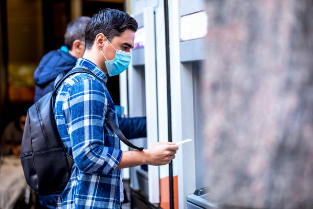 istock Man using a credit card in an atm for cash withdrawal 1216251015