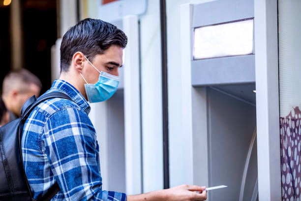 istock Man using a credit card in an atm for cash withdrawal 1216251114