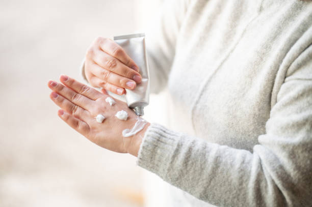 istock Woman drawing a smiley with hand cream on her hand 1216251146