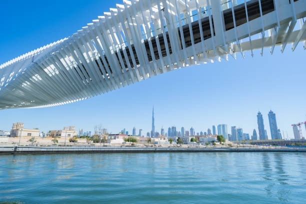 istock Twisted Bridge. Structure of architecture with lake or river, Dubai Downtown skyline, United Arab Emirates or UAE. Financial district and business area in urban city with blue sky background. 1216251873