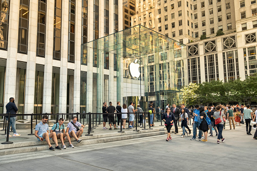 Manhattan, New York - September 21, 2019:  People line up outside the Apple computer retail store on Fifth Avenue near Central Park in Manhattan New York City USA