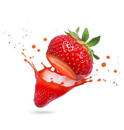 Juice splashes out from cutted strawberry on a white background