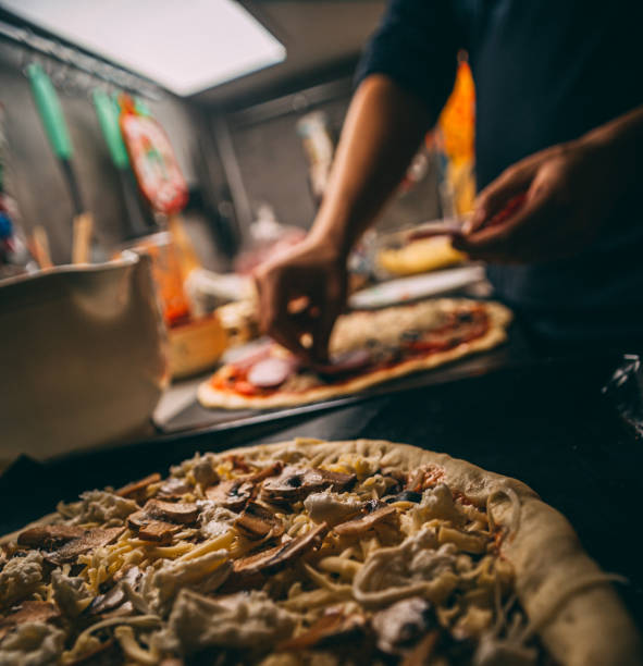 istock Closeup hand of chef baker in white uniform making pizza at kitchen 1216253388