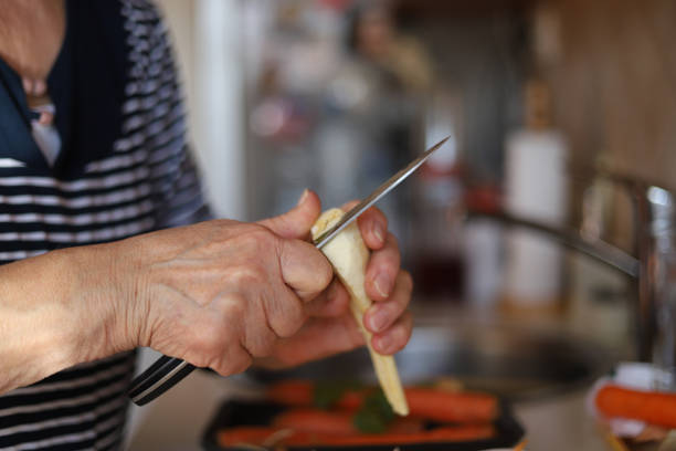 istock Woman peeling parsley root 1216254999