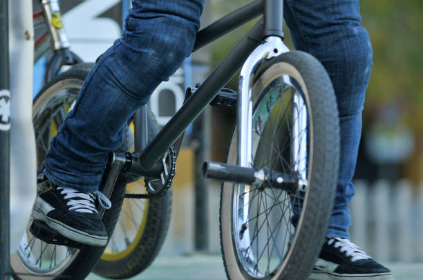 istock Bicycle wheel between legs with skate shoes 1216255435