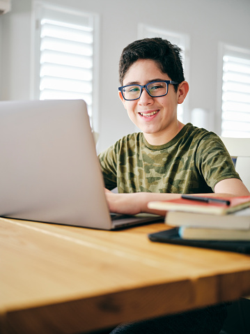 A student learning by doing schoolwork at home using a computer.