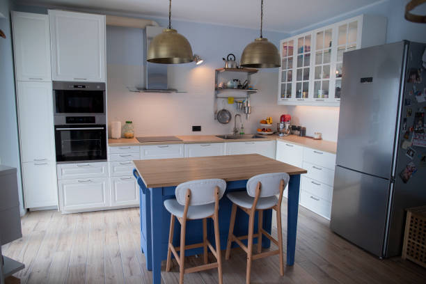 istock White kitchen with blue island and wooden floor. 1216262006