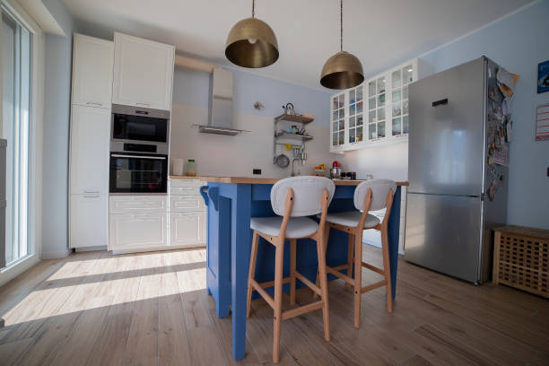 istock White kitchen with blue island and wooden floor. Low view. 1216262009