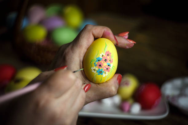 istock Woman hands painting eggs with floral patterns acrylic. Decorating egg. Preparation for Easter. Selective focus. Close-up. Horizontal orientation. Copy space. 1216262497