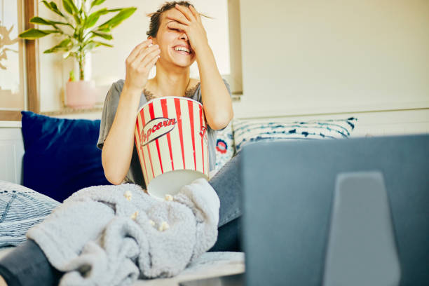 Cute woman eat popcorn and watching movie at home. Cute woman eat popcorn and watching movie at home. popcorn snack bowl isolated stock pictures, royalty-free photos & images