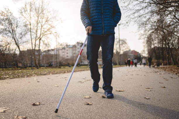 istock Front view of a blind man walking in a public park 1216271486
