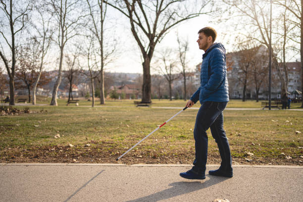 istock Side view of a blind man walking in a public park 1216271495