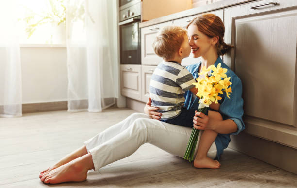 filho pequeno parabenizando a mãe na cozinha - flower spring bouquet child - fotografias e filmes do acervo