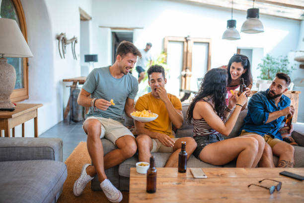 amigos disfrutando de cervezas y aperitivos en casual social gathering - patatas fritas tentempié fotografías e imágenes de stock