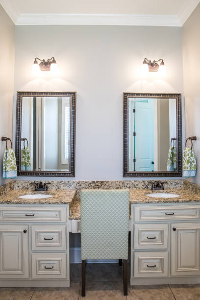 istock Large neutral cream colored master bathroom with double sinks, two mirrors and a granite countertop in a new construction modern home 1216278334