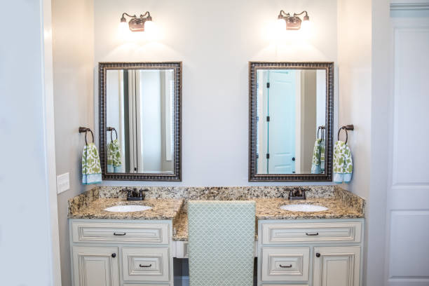 istock Large neutral cream colored master bathroom with double sinks, two mirrors and a granite countertop in a new construction modern home 1216278344