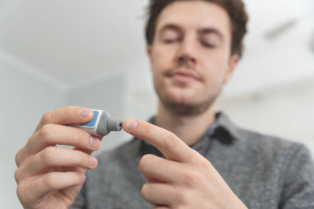 istock Young man measures blood sugar level. 1216278370