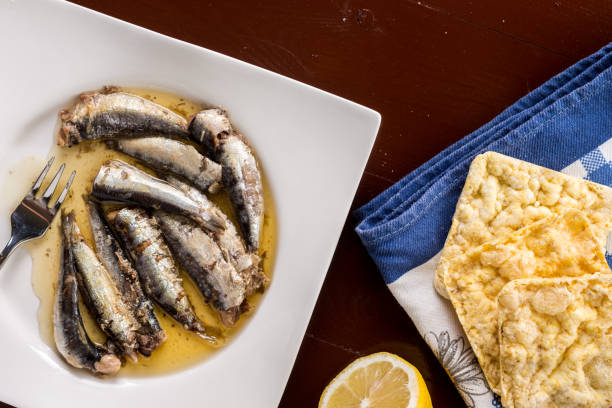 istock Marinated sardines in the oil served with lemon and corn bread 1216281690