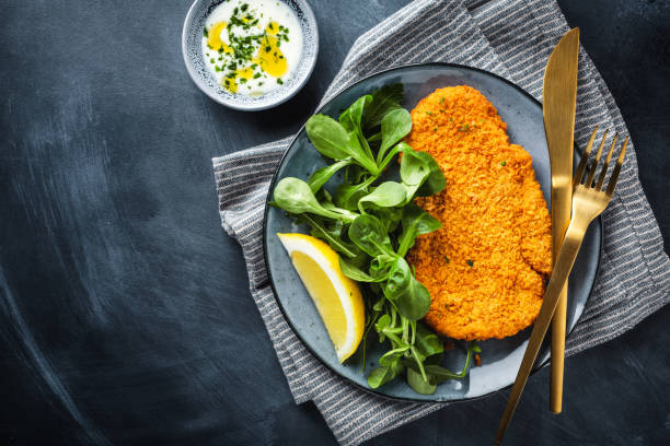 German schnitzel with vegetables on plate Classic german or austrian schnitzel with salad served on plate. scaloppini stock pictures, royalty-free photos & images