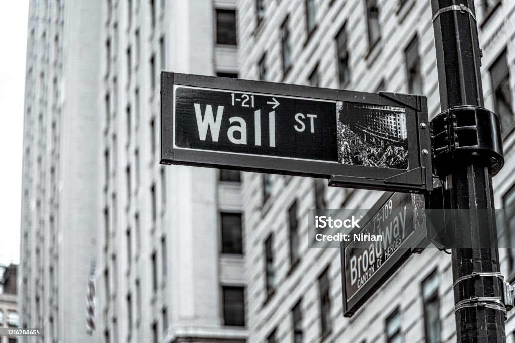 Wall Street New York City Wall Street road sign in downtown Manhattan with skyscrapers. Wall Street - Lower Manhattan Stock Photo