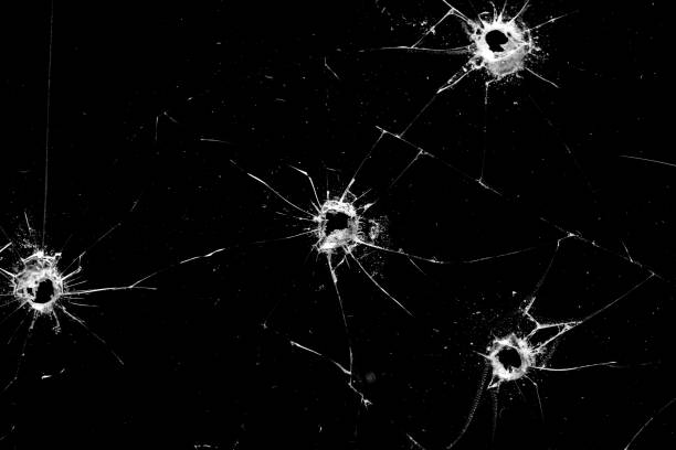 istock holes in the glass with cracks isolated on a black 1216291172