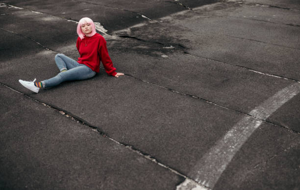 расслабленный хипстер, сидящий на выветривих треках - child looking messy urban scene стоковые фото и изображения