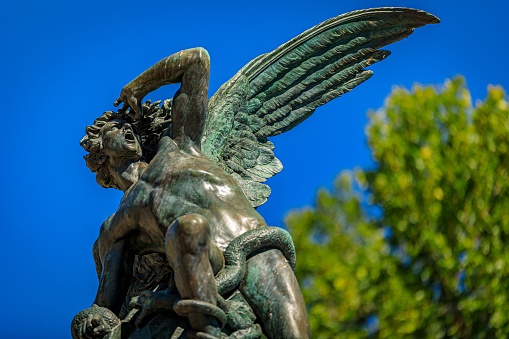 Close up of the Fountain of the Fallen Angel or Fuente del Angel Caido in the Buen Retiro Park in Madrid, Spain inaugurated in 1885