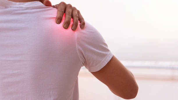 l'uomo che soffre alla spalla e usa la mano per massaggiare per ottenere il dolore. - pain shoulder human joint cramp foto e immagini stock