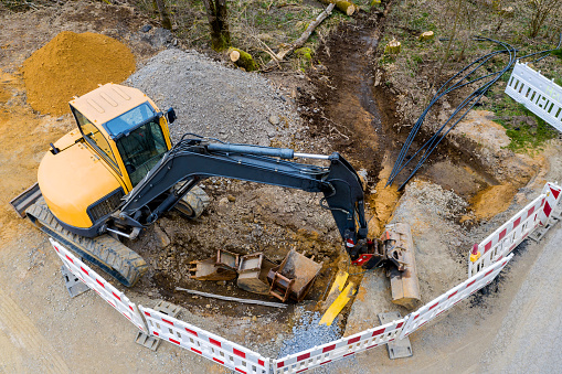 an excavator on an cable construction site from above