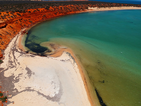 The red cliffs of Francois Peron National Park stand in counterpoint to the turquose waters of Shark Bay, Western Australia presenting a spectacular explosion of colour