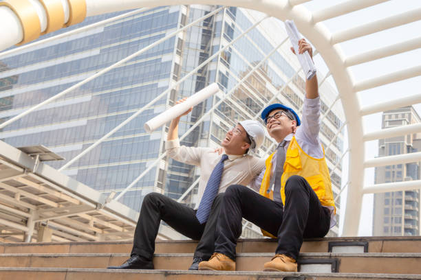 concepto de éxito y felicidad, ingeniero de negocios sosteniendo papel de dibujo en la mano en la ciudad fuera de la oficina. - construction worker architect construction manual worker fotografías e imágenes de stock