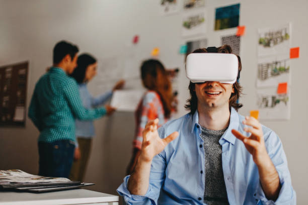 istock Man using virtual reality glasses in design office studio next by coworkers 1216308761