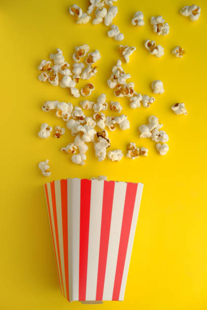 istock top view of popcorn spilling on yellow background 1216308776