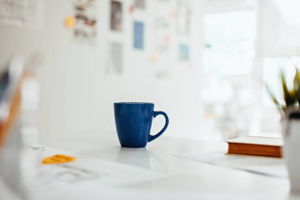 Blue coffee mug on desk in bright modern business design office