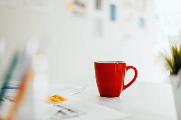 istock Red tea cup on desk in business design office 1216308951