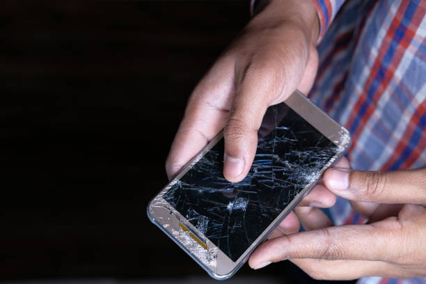 istock hand holding broken smart phone wooden table 1216310460