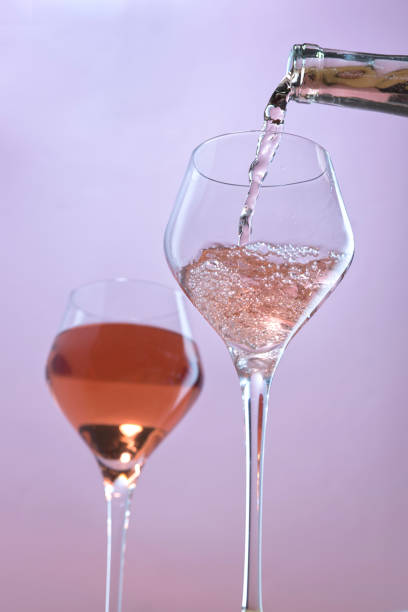 A concept studio image of pouring rose wine into a wine glass.
