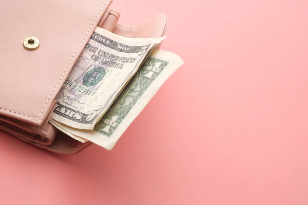istock Pink wallet and Us dollar banknotes on pink background 1216310479