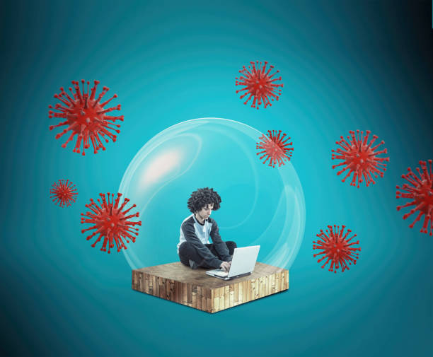 istock Social distancing and self-isolation during corona virus quarantine. Work from home concept . Man working online on a laptop inside a bubble protection shield . 1216314299