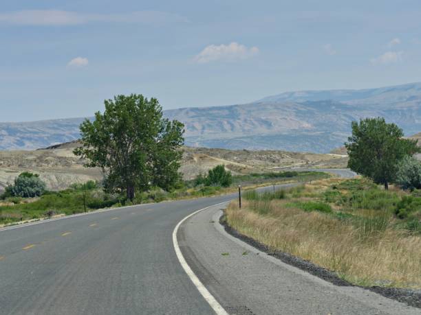 istock Montana landscape with a road winding around rolling hills. 1216315053