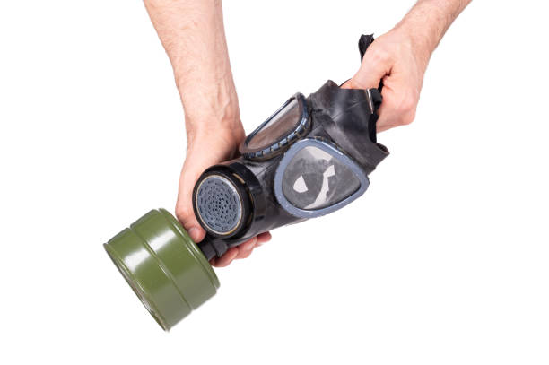 istock Man holding vintage gasmask isolated on white background - Green filter 1216321401