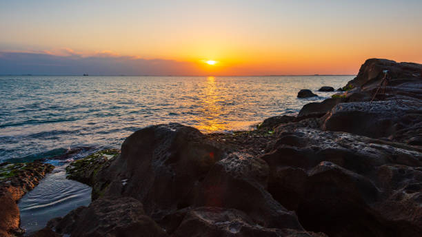istock Camera on a tripod shoots a colorful sunrise at sea 1216321488