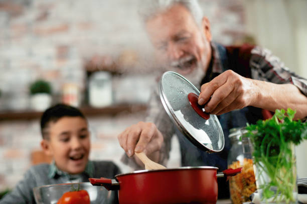 istock Grandfather and grandson cooking in kitchen. 1216322768