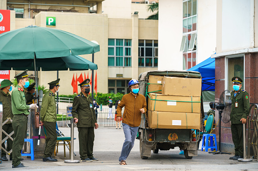 Hanoi, Vietnam - Mar 31, 2020: Control activities at main entrance of Bach Mai hospital, locked down as a major Covid-19 outbreak area, during covid-19 coronavirus pandemic