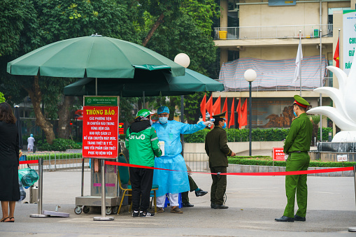 Hanoi, Vietnam - Apr 1, 2020: Control activities at main entrance of Bach Mai hospital, locked down as a major Covid-19 outbreak area, during covid-19 coronavirus pandemic